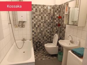 een badkamer met een bad, een toilet en een wastafel bij Duża kawalerka Kossaka 12B -balkon -dla max 4osób przy galeri kasztanowa Centrum in Piła +6 foto's