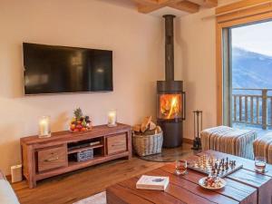 a living room with a television and a fireplace at Chalet des Etoiles Les Masses in Hérémence