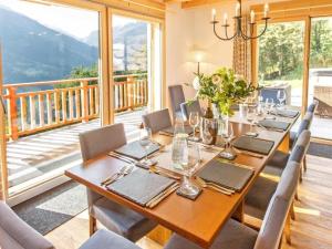 a dining room with a table and chairs and a balcony at Chalet des Etoiles Les Masses in Hérémence