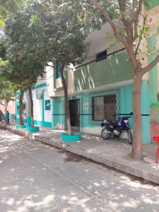 Hotel Unico City في سانتا مارتا: مبنى أزرق به دراجة نارية متوقفة في الشارع