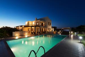 a swimming pool in front of a house at night at 5 bedroom Villa Poseidon with private pool, Aphrodite Hills Resort in Kouklia