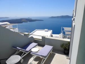a balcony with chairs and a view of the water at Avant Garde Firostefani in Firostefani