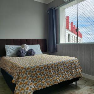a bedroom with a bed with a teddy bear on it at Apartamento frente à praia in Santos