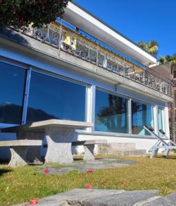un banco frente a un edificio con balcón en Villa "Genovese al Lago", en Minusio