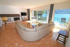 sala de estar con sofá grande y vistas al océano en Villa "Genovese al Lago", en Minusio