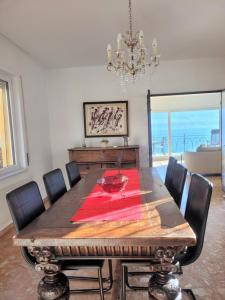 uma sala de jantar com uma mesa com cadeiras e um lustre em Villa "Genovese al Lago" em Minusio