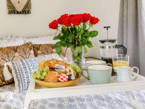a tray with a plate of food on a bed with roses at 1 bed in Symonds-Yat 88590 in Goodrich
