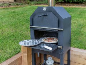 a pizza being cooked in an outdoor oven at 1 bed in Symonds-Yat 88590 in Goodrich