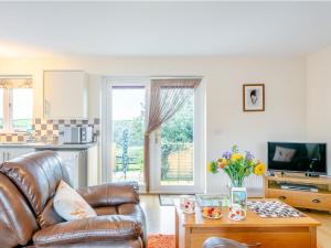 a living room with a leather couch and a table at 1 Bed in Swimbridge LANEE in Swimbridge