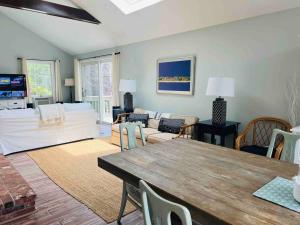a living room with a table and a couch at Beautiful Cape Cod home! Steps to beach! in Mashpee +32 photos