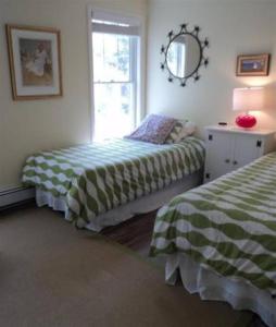 a bedroom with two beds and a mirror at Beautiful Cape Cod home! Steps to beach! in Mashpee