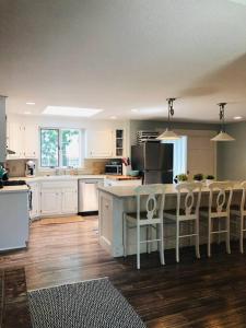 a kitchen with white cabinets and a table and chairs at Beautiful Cape Cod home! Steps to beach! in Mashpee
