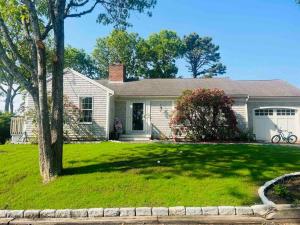 a white house with a tree in a yard at Beautiful Cape Cod home! Steps to beach! in Mashpee