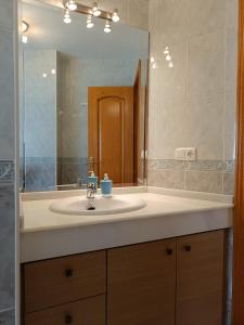 baño con lavabo y espejo grande en Los Maestros: ático en el centro de Vélez-Málaga, en Vélez-Málaga