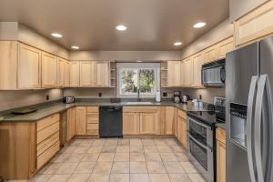 a kitchen with wooden cabinets and black appliances at Riverside Cabin home in Leavenworth