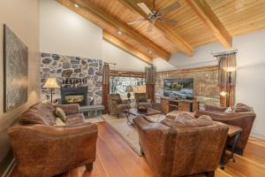 a living room with leather furniture and a stone wall at Riverside Cabin home in Leavenworth