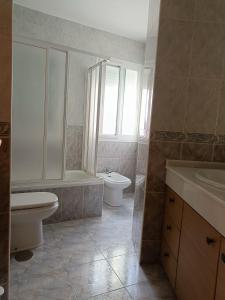 y baño con aseo, bañera y lavamanos. en Los Maestros: ático en el centro de Vélez-Málaga, en Vélez-Málaga