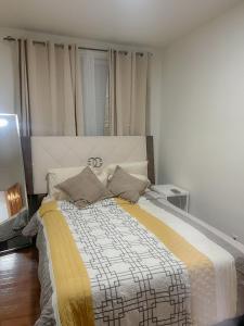 a bedroom with a bed with a yellow and white blanket at 2 Bedroom Bliss in College Point in College Point