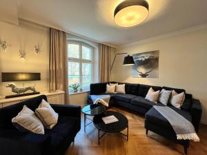 a living room with a couch and a table at Jagdschloss Suite - premium castle hideway in Hohen Niendorf