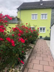 ein gelbes Haus mit roten Blumen davor in der Unterkunft Fewo Linda 2 in Gunzenhausen