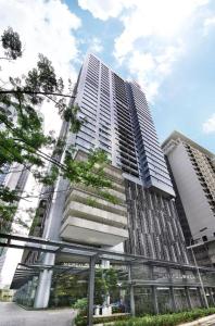 吉隆坡的住宿－Mercu Summer Suites KLCC By Sweet Home，前面有树木的高楼