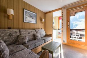 ein Wohnzimmer mit einem Sofa und einem Tisch in der Unterkunft Quartier Crève Cœur - maeva Home - Appartement 2 pièces 4 personnes 21 in Valmorel