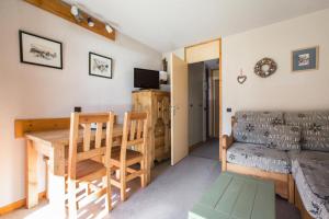 a living room with a table and a couch at Quartier Crève Cœur - maeva Home - Appartement 2 pièces 4 personnes 21 in Valmorel