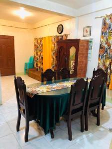 a dining room table with a green tablecloth and chairs at 15pax-U2-Rose&Fer Vigan Transient-Near Calle Crisologo in Bantay
