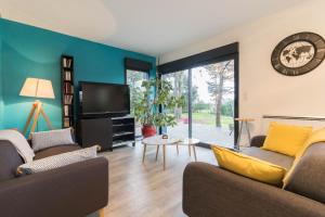 ein Wohnzimmer mit 2 Sofas und einem TV in der Unterkunft Chambres D'hôte Le Cèdre Bleu in Saint-Jean