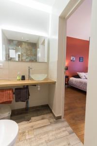 ein Bad mit einem Waschbecken und ein Bett in einem Zimmer in der Unterkunft Chambres D'hôte Le Cèdre Bleu in Saint-Jean
