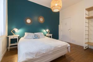 ein Schlafzimmer mit einem großen Bett mit zwei Lampen an der Wand in der Unterkunft Chambres D'hôte Le Cèdre Bleu in Saint-Jean