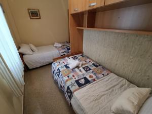 2 camas en una habitación pequeña con 2 camas en Los Maestros: ático en el centro de Vélez-Málaga, en Vélez-Málaga