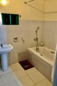 a bathroom with a sink and a bath tub next to a sink at 15pax-U2-Rose&Fer Vigan Transient-Near Calle Crisologo in Bantay