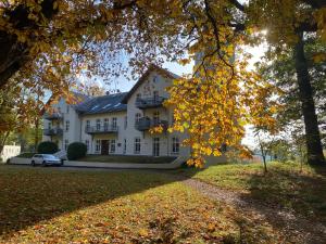 a large white house with a car parked in front of it at Jagdschloss Suite - premium castle hideway in Hohen Niendorf