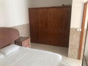 sypialnia z łóżkiem i drewnianymi drzwiami w obiekcie Murdeira village V155J r/c w Espargos