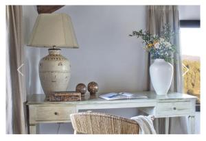 a table with a lamp and a vase on it at MasQi, The Energy House in Bañeres de Mariola