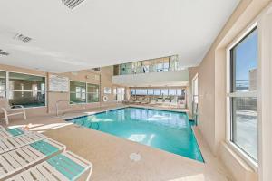 a large swimming pool in a building with a large window at Crystal Shores Unit 1405 in Gulf Shores