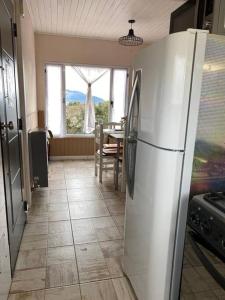 cocina con nevera blanca y mesa en Chez Gla - Alojamiento Bariloche en San Carlos de Bariloche