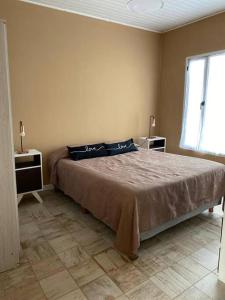 1 dormitorio con 1 cama grande, 2 mesas y ventana en Chez Gla - Alojamiento Bariloche en San Carlos de Bariloche
