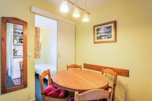 ein Esszimmer mit einem Holztisch und Stühlen in der Unterkunft Résidence Les Horizons d'Huez - maeva Home - Appartement 2 pièces 4 personn 59 in Huez