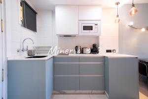 eine Küche mit weißen Schränken und einer Mikrowelle in der Unterkunft M328 - Studio - Complex Minerva & Jupiter in Benalmádena