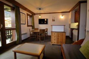 a living room with a table and a dining room at Quartier La Forêt - maeva Home - Appartement 3 pièces 6 personnes Sélection MAE-5126 in Valmorel