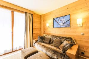 a living room with a couch and a tv at Résidence Les Chalets du Forum - maeva Home - Appartement 2 pièces 6 person 30 in Courchevel