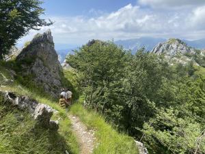 dwoje ludzi spacerujących ścieżką w górach w obiekcie Lovely Tuscan Mountain Village w mieście Sassi