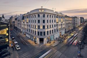 a large white building on a city street with traffic at Smart park view studio in heart of Riga 5 min to Old Town in Riga