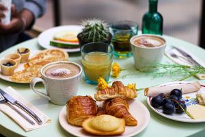ロワシー・アン・フランスにあるメルキュール パリ ロワシー CDGの朝食用の食品とドリンクの盛り合わせが備わるテーブル