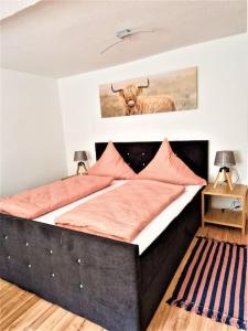 a bedroom with a bed with a bull on the wall at modernes Landhaus Charlie - Nähe Halle, 4 Zimmer in Petersberg