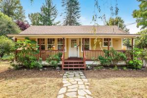 a small yellow house with a front porch at 118 - The Willow Tree Bungalow in Fall City