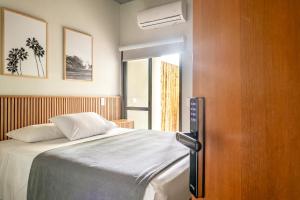 1 dormitorio con 1 cama y puerta de madera en JQY Beach Flats - Piscina - Carregador de veículos elétricos e híbridos - Garagem Subterrânea - Ar condicionado - WI-FI en Juquei