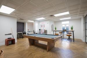 an office with a pool table in the middle of a room at Live Beautifully Uptown in Charlotte